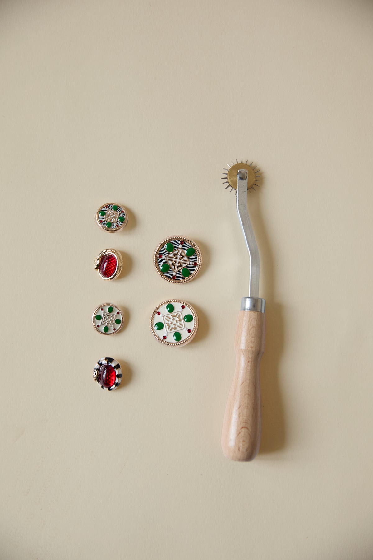 Every collection gets its own buttons, cast and finished by hand. Snakes, sunbursts, animals, symbols lifted from whatever the collection is about. They are wildly over-engineered for the job of holding a jacket shut, and that is the point.